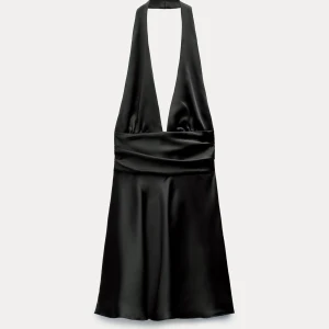 Svart halterneck klänning i satin - Säljer min festliga klänning från Zara. Aldrig använd! Den har öppen rygg med rosett i ryggen. Perfekt till nyårsfiranden 