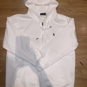 Polo Ralph Lauren Kofta - Säljer en stilren vit hoodie från Polo Ralph Lauren, jag har använt den max 7 gånger men nu vill jag sälja, kontakta för mer information 