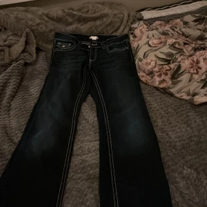 Mörkblå bootcut jeans Gina Tricot - Snygga mörkblå jeans från Gina Tricot i storlek 164. Modellen har bootcut-ben, kontrastsömmar och coola fickdetaljer med lock och knapp både fram och bak. Klassisk femficksdesign och tillverkade i jeansmaterial.