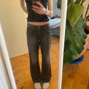 Mörka bootcut jeans med låg midja -  Ettt par mörkgrå/svarta lågmidjade bootcut jeans! Köpte dom på en secondhand i Stockholm och det står inget märke eller storlek, men skulle säga att dom är S. Dom är lite stora på mig så därför ser man inte bootcut modellen så bra. 