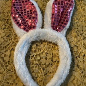 Diadem med glittrig kaninöron  - Säljer två fluffiga diadem med kaninöron, perfekta för påsk eller fest. Ena diademet har vita öron med insida i glittrig rosa och det andra har insida i glittrig silver. Båda har mjuk pälsimitation runt bågen och öronen.  85kr/2st 