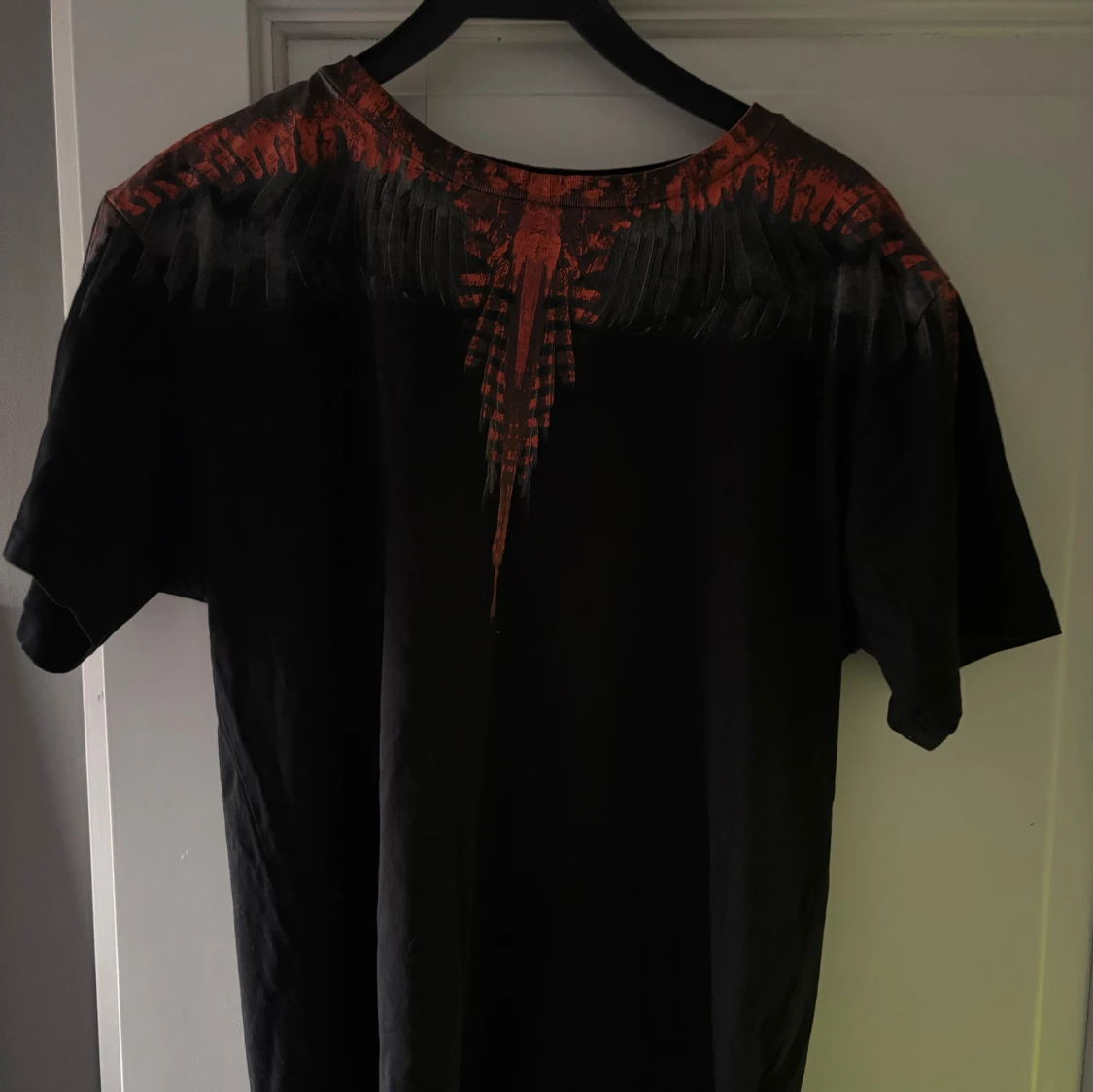 Svart t-shirt med röd grafik från Marcelo Burlon
