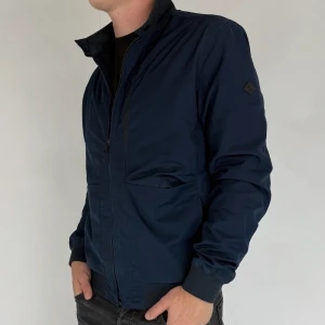 J.Lindeberg Jacka - Vi säljer nu denna stilrena Jacka i märket J.Lindeberg! Jacka är i storleken M, modellen på bilden är 180cm 75kg! Västen är i gott skick utan några defekter. Skriv gärna vid frågor och funderingar!