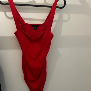 Röd ribbad body - Superfin röd ribbad body – sitter perfekt och framhäver figuren! En riktig basfavorit som funkar till allt från jeans till kjol. Använd ett fåtal gånger, i toppskick