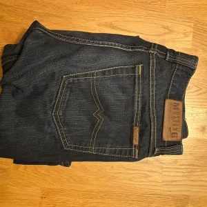 Mörkblå jeans från Mustang - Snygga mörkblå jeans från Mustang. Jeansen har raka ben och normal passform, tillverkade i slitstarkt denimtyg. Perfekta för dig som gillar en tidlös och clean look. Storlek 33/34