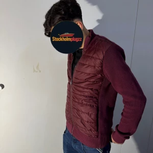  Cardigan jacka  - Säljer en vinröd cardigan jacka från Jimmy Sanders i storlek S. Jackan har quiltad framsida i syntetmaterial och stickade ärmar och rygg. Dragkedja framtill och ribbade muddar ger en clean och modern look. Perfekt för dig som vill ha något stilrent och bekvämt. Använd fåtal gånger frågor och annat besvaras pv‼️