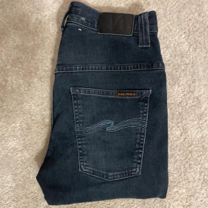 Mörkblå Nudie Jeans - Säljer dessa riktigt snygga marinblåa nudie jeans slim fit! 👖 Modell: THIN FINN, Färg: BLUE STRIKE (riktigt sällsynt). Storlek: W28 L32. Byxorna är i mycket bra skick! Nypris 1600 kr. Hör av er ifall ni har några frågor! 🙌⚜️⭐️