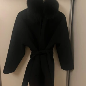 Svart kappa med pälskrage och bälte - Snygg svart kappa med stor mink pälskrage. 