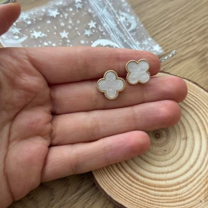 Vita  örhängen van cleef inspirerade med guldkant - Supersöta örhängen med vit pärlemor - van cleef inspirerade. Kommer i fin presentpåse på bilden - perfekta som present 💝helt nytt skick!  Perfekta för dig som gillar unika detaljer och vill ha något som sticker ut. 