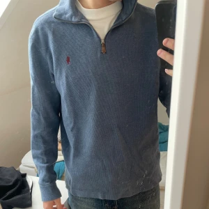 Blå half zip tröja från Polo Ralph Lauren - Säljer en blå långärmad tröja från Polo Ralph Lauren med half zip och klassisk röd logga på bröstet.