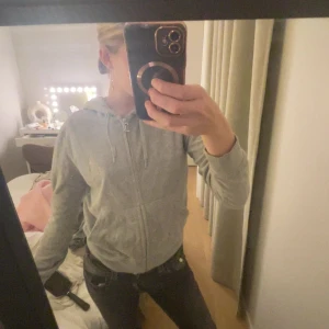 Juicy couture tröja  - Grå hoodie med dragkedja och huva. Tröjan har snörning i huvan och är långärmad. Perfekt för en avslappnad och chill stil. Passar bra till jeans eller mjukisbyxor.