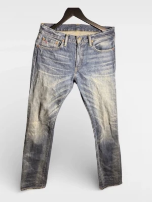 Ralph lauren blå slitna jeans herr - Klassiska blå Ralph lauren jeans med slitningar och tvättade detaljer för en cool, avslappnad look. Femficksmodell med raka ben och läderpatch bak i midjan. Tillverkade i robust denim som ger en tidlös streetstyle-vibe.