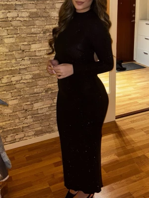 Glittrig svartklänning - Använd endast ett tillfälle. Mycket bra skick och snygg klänning som är glittrig. Den har en öppen rygg. 