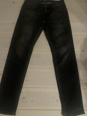 Svarta jeans från Jack & Jones - Snygga svarta jeans från Jack & Jones med raka ben och klassisk femficksdesign. Jeansen har diskreta slitningar och kontrastsömmar för en cool look. Perfekta till vardags och passar till det mesta. Materialet är troligtvis bomull med stretch.