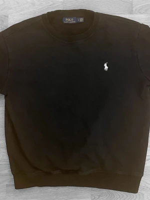 Svart Ralph Lauren tröja - Svart tröja från Polo Ralph Lauren med klassisk rund hals och långärmad design. Storlek L men passar bättre som storlek M 