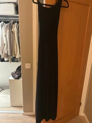 Svart långklänning med slits - Super fin svart lång klänning med slits och knyte i ryggen, materialet är väldigt stretchigt och passar mig som vanligtvis har storlek S. 💕💕köpt för 1800, har tyvärr inga egna bilder då den aldrig är använd men kan fixa om det skulle behövas! 