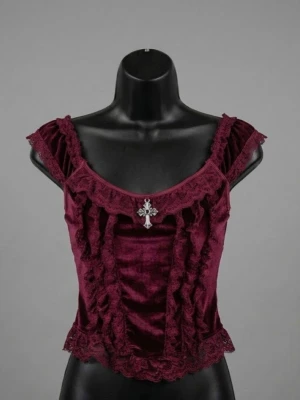 Vinröd sammetskorsett med spets - Supersnygg vinröd korsettopp i sammet med spetsdetaljer och dekorativt korshänge framtill. Toppen har breda axelband och volangkant längs nederdelen för en extra romantisk vibe.