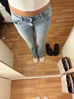 Ljusblå bootcut jeans från Lager 157 - Säljer ett par ljusblå raka jeans från Lager 157 med klassisk femficksdesign och hög midja. Jeansen har en snygg tvättad look och är tillverkade i denim med en skön passform. Perfekta till en avslappnad stil och passar till det mesta. Jeansen har dock ett hål i sidan bild finns som är ihopsytt men det stör ej funktionen.