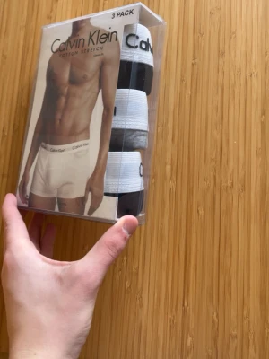 Calvin Klein 3-pack kalsonger - Säljer ett 3-pack kalsonger från Calvin Klein i modellen Cotton Stretch. Färgerna är svart, vitt och grått. Klassisk passform med bred resår i midjan där Calvin Klein-loggan syns tydligt. Materialet är mjuk och stretchig bomull för extra komfort.