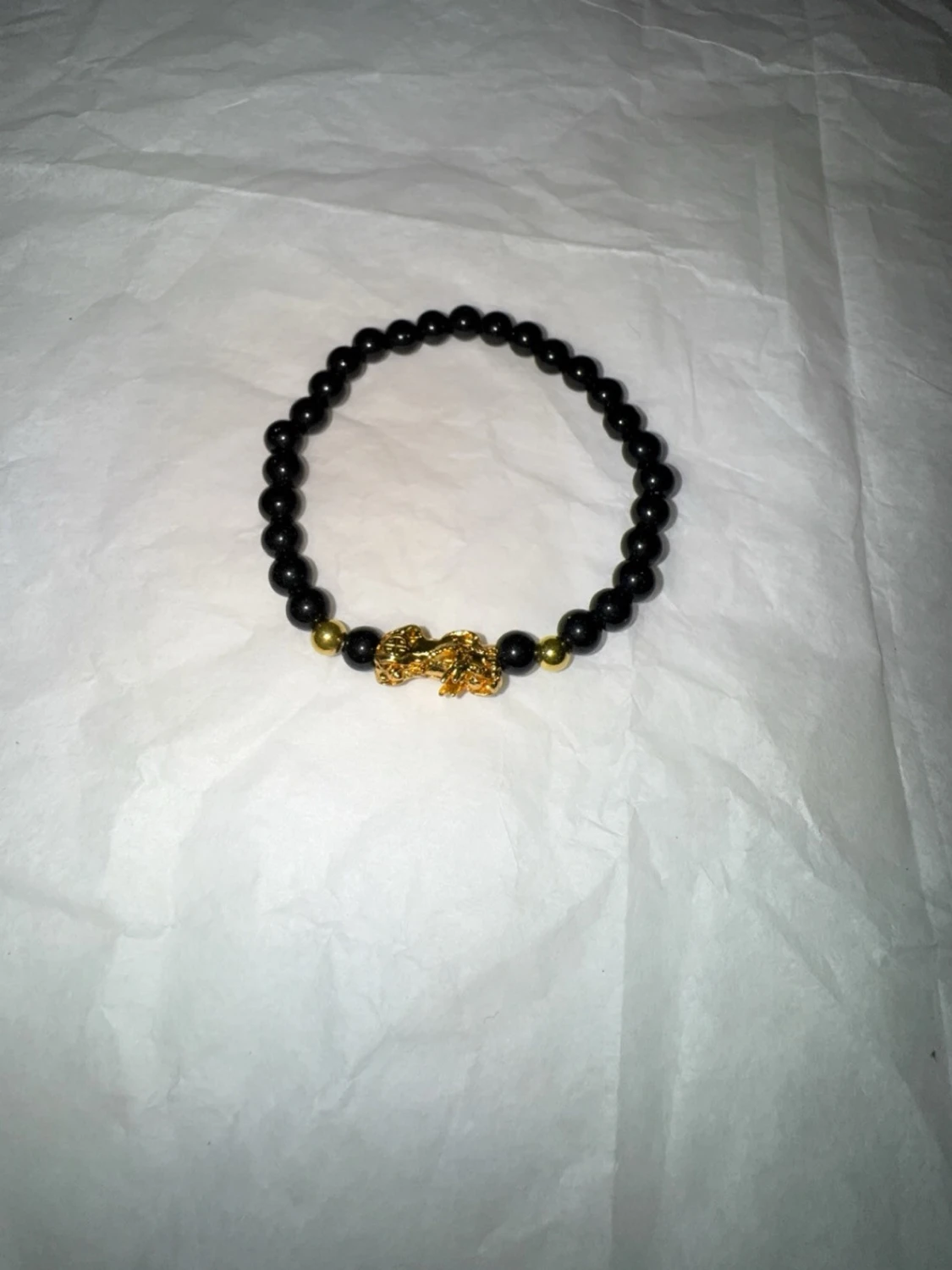 Svart pärlarmband med gulddetalj