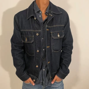 Jeansjacka  - Snygg mörkblå slutsåld jeansjacka från Arket med klassisk krage och kontrastsömmar. Pris kan diskuteras vid snabb affär.