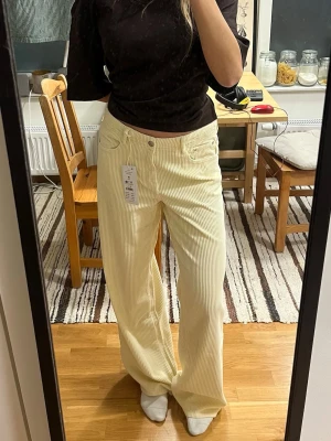 Ljusgula manchesterbyxor - Snygga vida manchesterbyxor från G i en ljusgul nyans. Byxorna har klassisk femficksdesign, hällor för bälte och stängs med knapp och dragkedja. Perfekta för dig som vill ha en chill och trendig look.