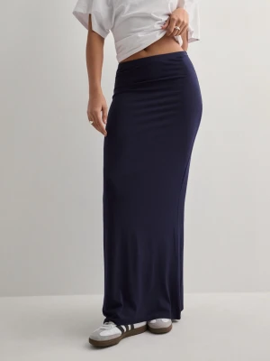 Mörkblå långkjol i stretchigt material - Mörkblå långkjol med figurnära passform och hög midja. Kjolen är tillverkad i ett mjukt och stretchigt material som ger en snygg siluett. Perfekt att styla med sneakers eller sandaler för en avslappnad look.