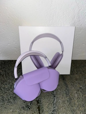 Lila Apple AirPods Max hörlurar - Säljer ett par snygga lila Apple AirPods Max med matchande Smart Case. Over-ear design med mjuka öronkuddar och justerbart huvudband i metall och mesh. Grym ljudkvalitet och stilren look, perfekt för musik och poddar.