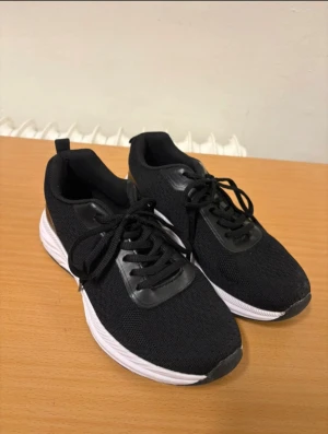 Svarta sneakers från Kayoba Outdoor - Svarta sneakers från Kayoba Outdoor med vit platt sula och rund tå. Storlek 39.