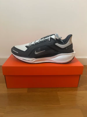 Nike Pegasus GORE-TEX strl 43 (oanvända) - Nike Pegasus 41 GORE-TEX sneakers i storlek 43. Skorna är svart och vita och är designade för löpning och vardagligt bruk. Materialet inkluderar vattentätt Gore-Tex för skydd mot väta.