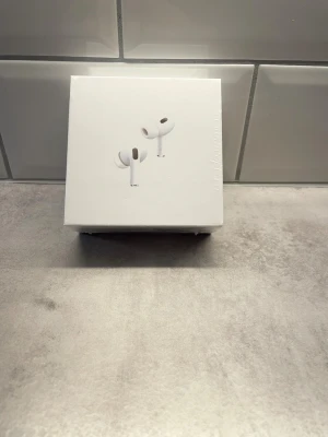 AirPods Pro 2nd Generation - Säljer ett par AirPods Pro 2nd Generation med MagSafe-laddningsetui. Komplett med originalförpackning, extra öronkuddar, laddningskabel och manualer. Hörlurarna och tillbehören är i nyskick, inga synliga defekter eller slitage. Perfekt för trådlös musik och samtal med aktiv brusreducering.