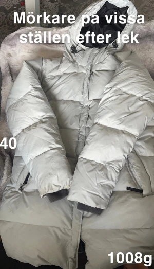 Ljusgrå lång vinterjacka med huva - Säljer en ljusgrå vinterjacka från Zero point med stor, mysig huva och quiltad design. Jackan har dragkedja framtill, ribbade muddar vid ärmslut och praktiska fickor. Perfekt för kalla dagar och riktigt skön att bära.🌸 Mörkare på vissa ställen. Storlek 40