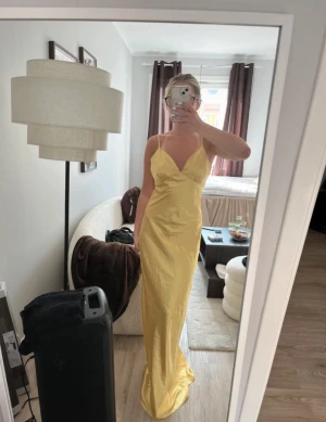 Gul långklänning - Gul balklänning/satinklänning från something new. Storlek XS, men skulle säga mer åt S. aldrig använd och lapp kvar. Är 161cm och den är för lång för mig.  Den är lite öppen i ryggen. Banden är justerbara.