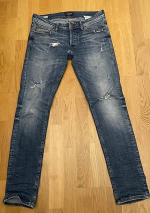 Blå jeans från Jack & Jones - Snygga blå jeans från Jack & Jones i modellen Slim Glenn 😊. Jeansen har slitna detaljer och lagom tvättad look. Storlek 31, bara att höra av er vid frågor 🙌
