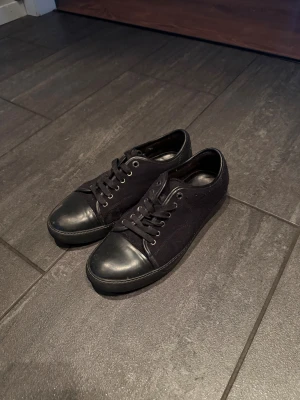 Lanvin  - Svarta sneakers från Lanvin. Storlek 43 bra skick förutom att de har skrapats bort på inne sidan av skon, syns om man kollar noga på skon.