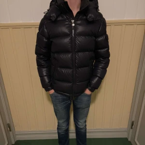 Navy Moncler MAYA - Säljer denna snygga navy maya jackan från Moncler med klassisk logga på ärmen och quiltad design. Jackan har huva, dragkedja framtill den klassiska serietidningsetikett på insidan. Perfekt för kalla dagar när du vill hålla stilen och värmen. Storlek 3 184 cm på bilden. Vid frågor vänligen kontakta mig! 🙌Givetvis möjlighet att gå ner i pris vid snabb försäljning. Denna går för 11500 hos merchsweden… Nypris 18000 hos moncler…