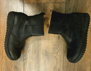Svarta boots från DinSko - Säljer ett par svarta boots från DinSko med grov sula och rund tå. Skorna är tillverkade i skinn och har mjukt, grått foder på insidan för extra värme. Dragkedja på sidan gör dem enkla att ta på och av. Perfekta för kalla dagar och har en stilren look. Jag använde dem bara en gång. De var leriga på grund av konstruktionen och det är därför det finns lite lera. De kan lätt rengöras med en våtservett. Jag rengör dem innan jag skickar dem.