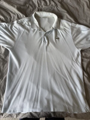 Ljusblå pikétröja från Lacoste - En helt okej använd Lacoste piké som har väldigt mycket användning kvar i sig. Pris kan diskuteras‼️