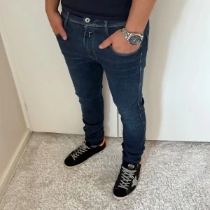 Replay Anbass Jeans - Säljer dessa feta jeansen från Replay! Jeansen är i slim fit modellen Anbass. Storlek: 32/32. De har en schysst mörkblå färg och har inga synliga skador eller andra defekter. Killen på bilden är ca 178cm lång! Tveka inte på att skriva om du har några frågor eller funderingar💯