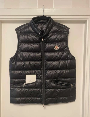 Svart dunväst från Moncler - Svart dunväst från Moncler med quiltad design. Size 4. Knappt använd. Kvitto finns med.