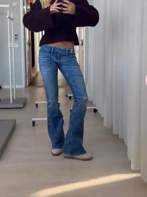 Blå bootcut jeans med låg midja - Säljer ett par blå bootcut jeans med låg midja och slitningar på benen. Super trendiga!! Storlek xs men passar mig som har 36 i jeans💓💓💓gina young 14+ avdelningen