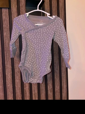 Omlott body i storlek 62 - Omlott body i storlek 62 med knäppning i grenen 