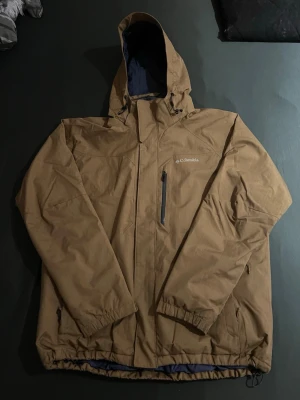 Brun skaljacka från Columbia  - Säljer en brun skaljacka från Columbia i storlek XL. Jackan är i ett bra skick men har dock ett pytte litet på vänster arm vid armfickan. (om du vill ha bild så kan jag lösa det) Jackan är använd en gång (en vecka) och man håller sig varm i jackan. Om du är nyfiken och har frågor så svarar jag snabbt! Frakt sker inom 24h!💨📦