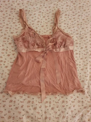 Rosa spetslinnetopp med rosett - Supersöt ljusrosa linnetopp med spetsdetaljer. Det stod inte vart den var ifrån eller vilken storlek den var, men skulle kunna tippa på en S/M❣️