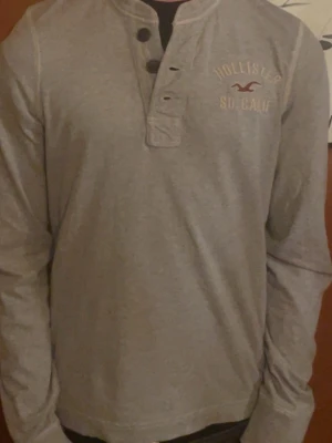 Grå långärmad tröja från Hollister - Säljer en as fet tröja från hollister i bra skick! Rimliga bud accepteras! 