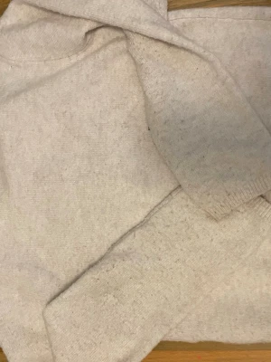 Beige kofta från Kappahl med knappar - Mysig beige kofta från Kappahl i storlek 146/152. Koftan är stickad och har långa ärmar samt knappar framtill. Perfekt för lager på lager under kyliga dagar. Enkel och stilren design som passar till det mesta. Koftan är lite knottrig men inget märkvärdigt 