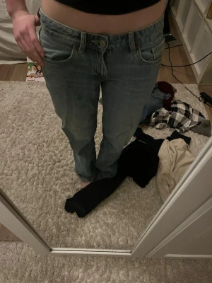 Zara ljusblå jeans lågmidjade baggy jeans - Säljer ett par baggy jeans från Zara i ljusblå tvätt. De har rak passform, lågmidja och är tillverkade i slitstarkt jeanstyg. Perfekta för dig som gillar en tidlös och avslappnad look. Passar till allt och är superbekväma.jjh 