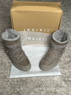 Inuikii skor - Hej nu säljer vi dessa helt nya Inuikii boots i en härlig beige färg. Varmt och bekväm fodring inuti som håller dig varm samt fodring på innersulan. Storlek: 38, innersulan på de dessa är ca 23-24cm. För fler frågor eller funderingar är det bara att skriva och höra av sig. 