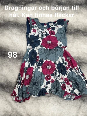 Blommig klänning - Säljer en söt klänning med stort blommigt mönster. Klänningen har ärmlös design och rund halsringning. perfekt för varma dagar. Passar dig som gillar färgglada och lekfulla plagg.🌸Dragningar i någon tråd ( ej hål) finns ett ställe som är början till hål. Diffusa fläckar. Storlek 98