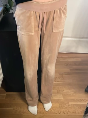 Beiga mjukisbyxor Juicy Couture XS - Säljer ett par beiga mjukisbyxor från Juicy Couture. Säljer då det ej kommer till användning längre. De är uppsydda i benen som ni kan se på bild fyra lite tydligare. Hör gärna av er innan köp🤗